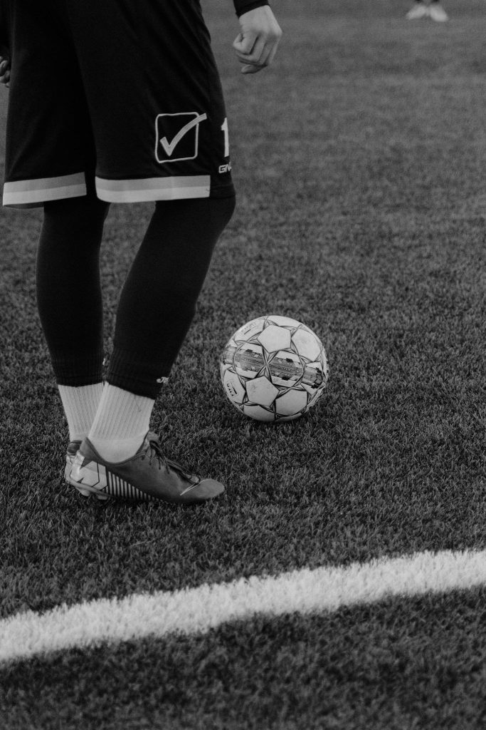 A Grayscale of a Person Playing Soccer